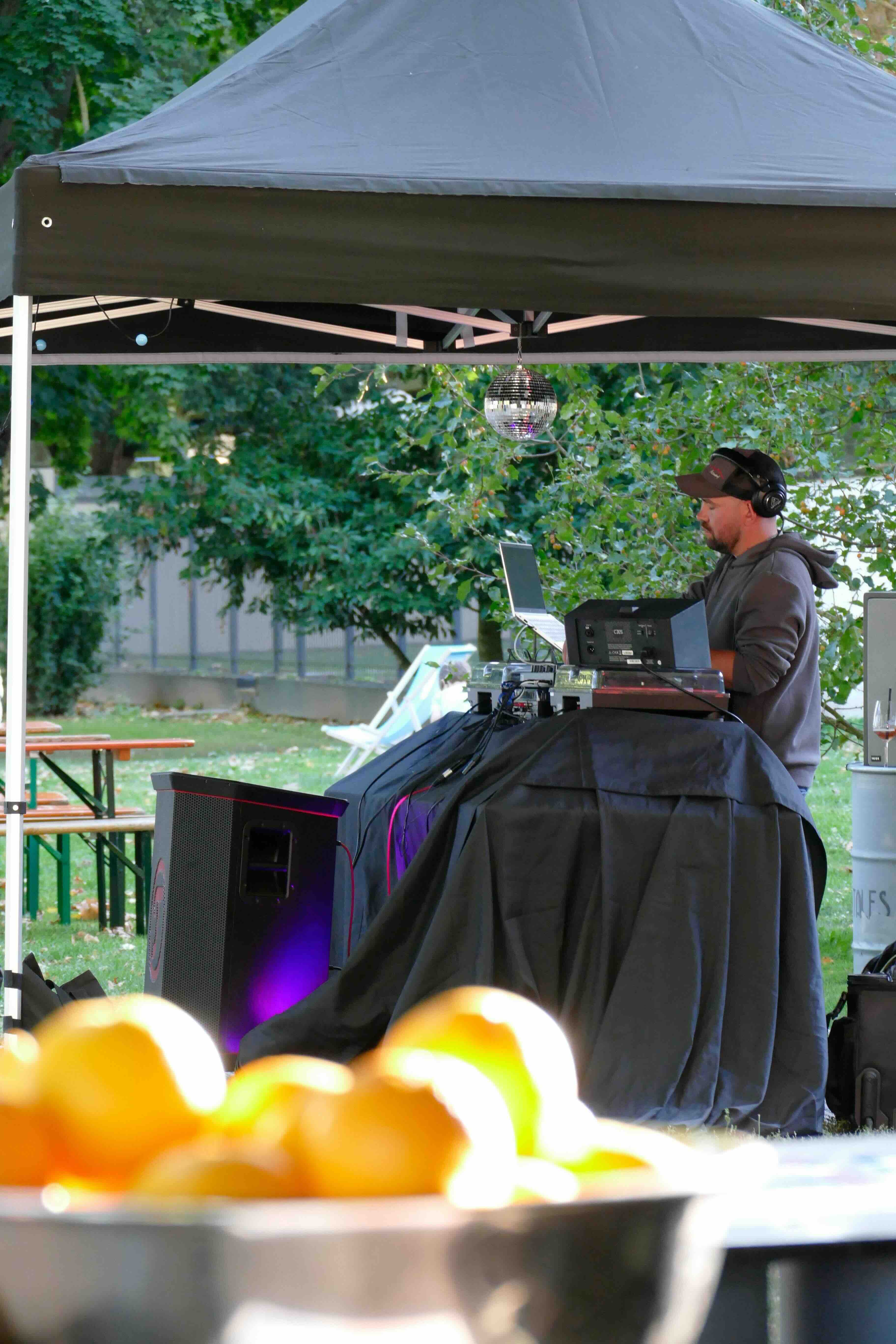 Ein DJ der an seinem Pult Musik spielt