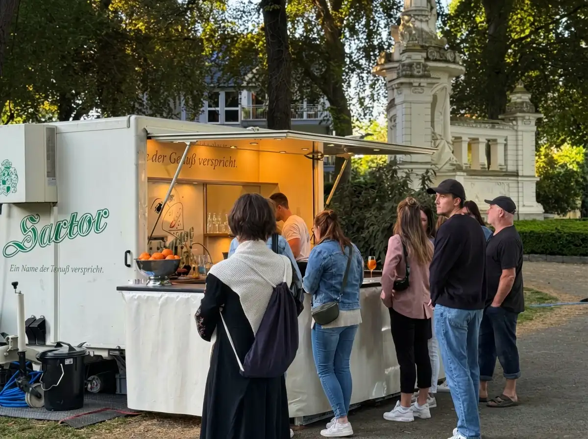 Menschen warten vor einen Sartor Weinstand und bestellen Wein