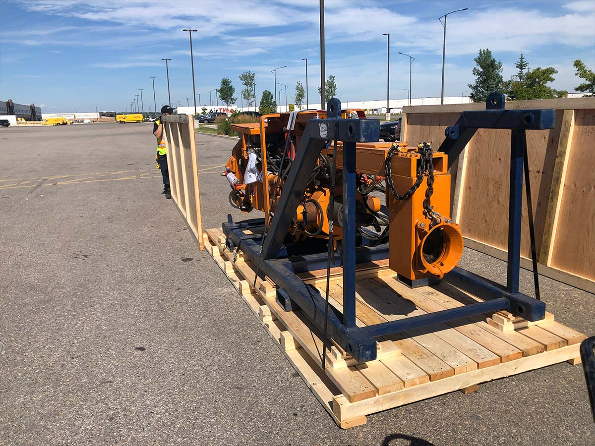 Crating crew securing a large machine inside a wooden export crate