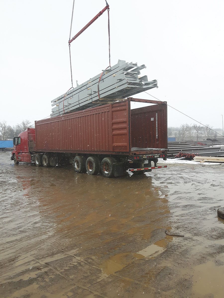 Long industrial equipment laid flat and braced along container floor