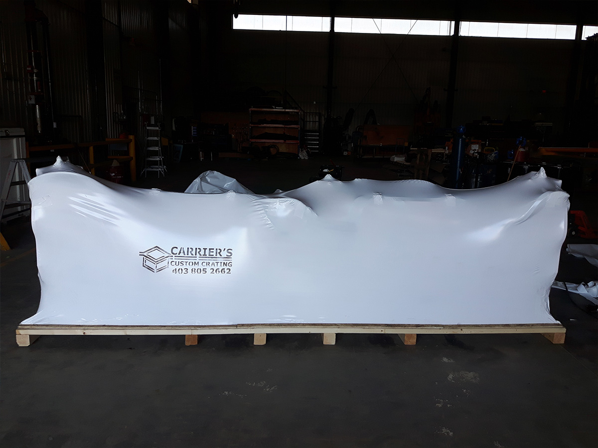 Heavy-duty industrial shrink wrap protecting equipment from road debris during transport