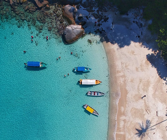 a beach with boats and people on it