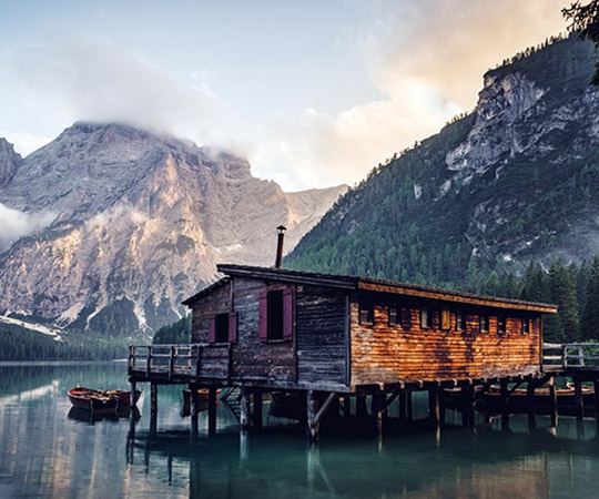 a small cabin sits on the edge of a lake