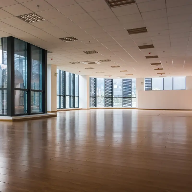 Wood-look plank flooring installed throughout an open commercial office space with floor-to-ceiling windows.