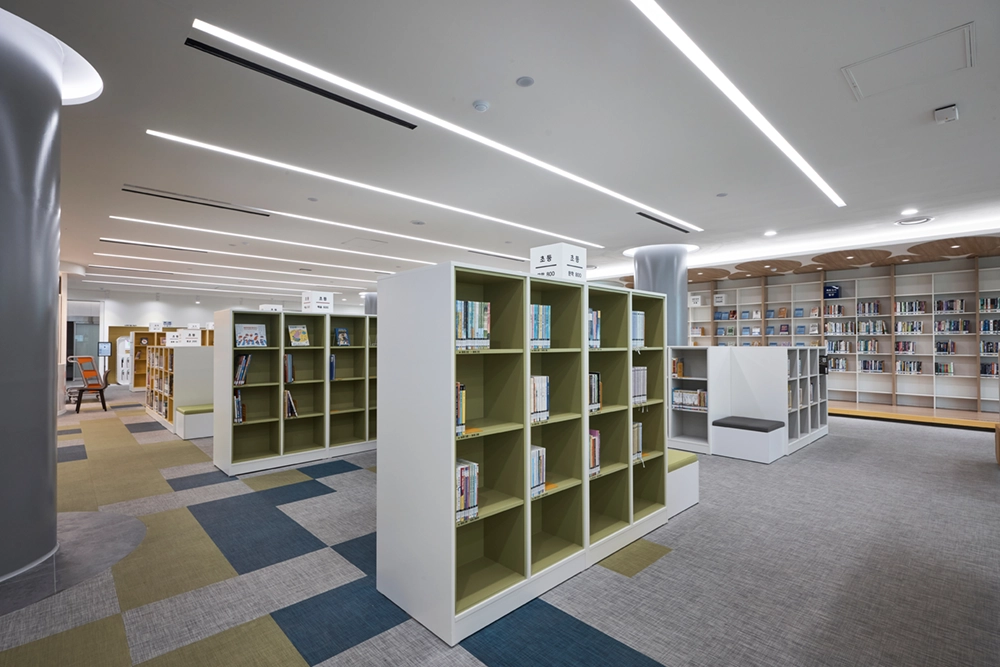 Multicolor carpet tile in a school library with low bookshelves and study seating.