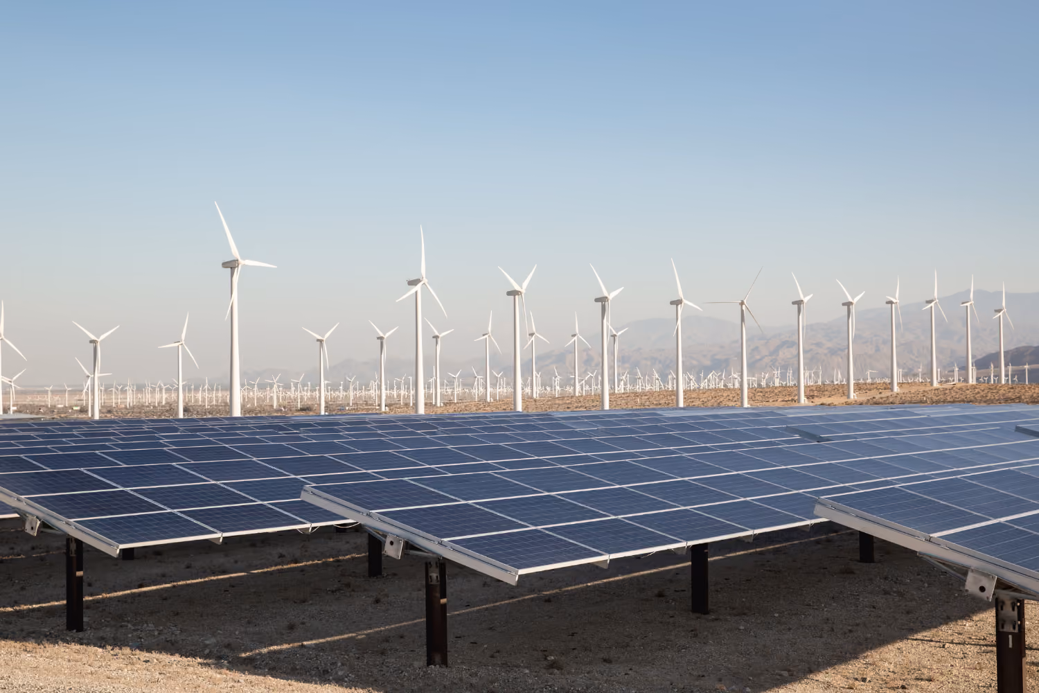 Solar farm and wind turbines generating renewable electricity.