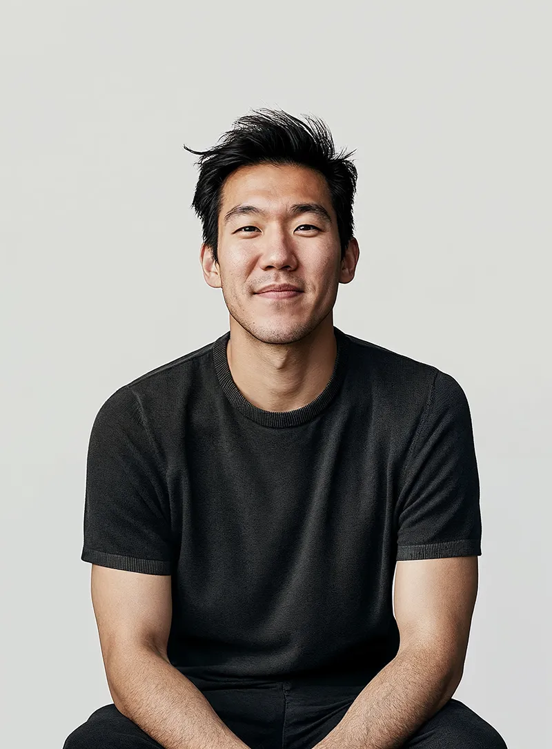 A man sitting on a stool in a black shirt.
