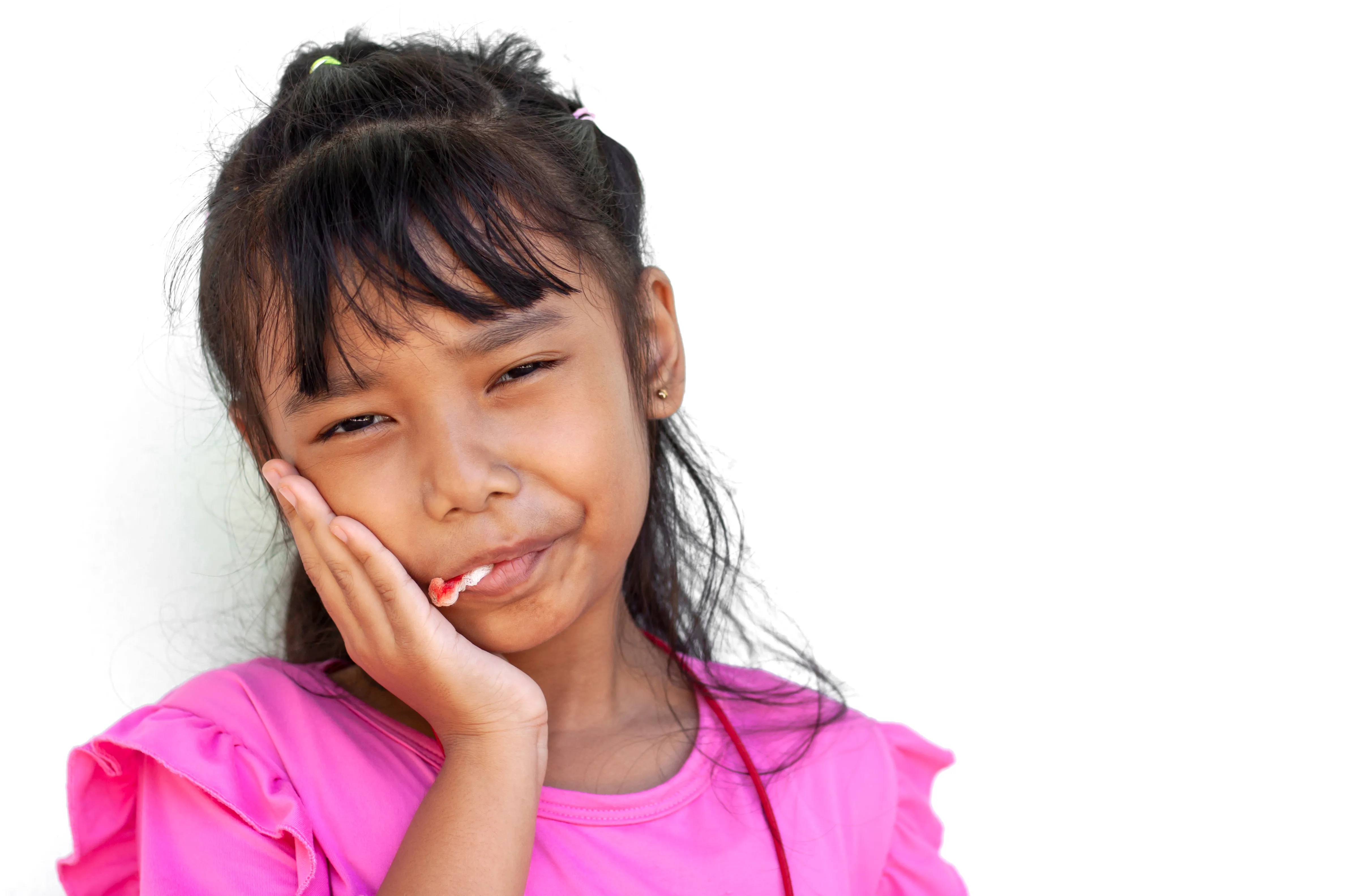 little girl biting the gauze in mount to stop the bleeding after the extraction