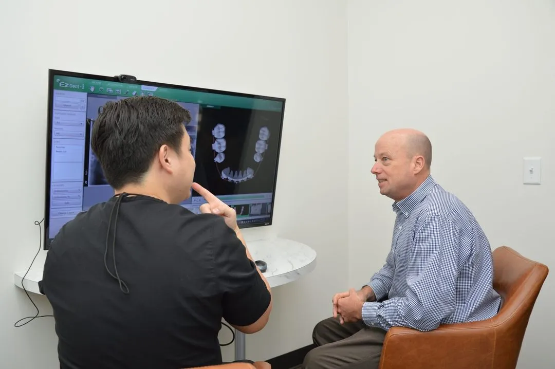 Dr. William Sung reviewing a 3D implant plan with a patient