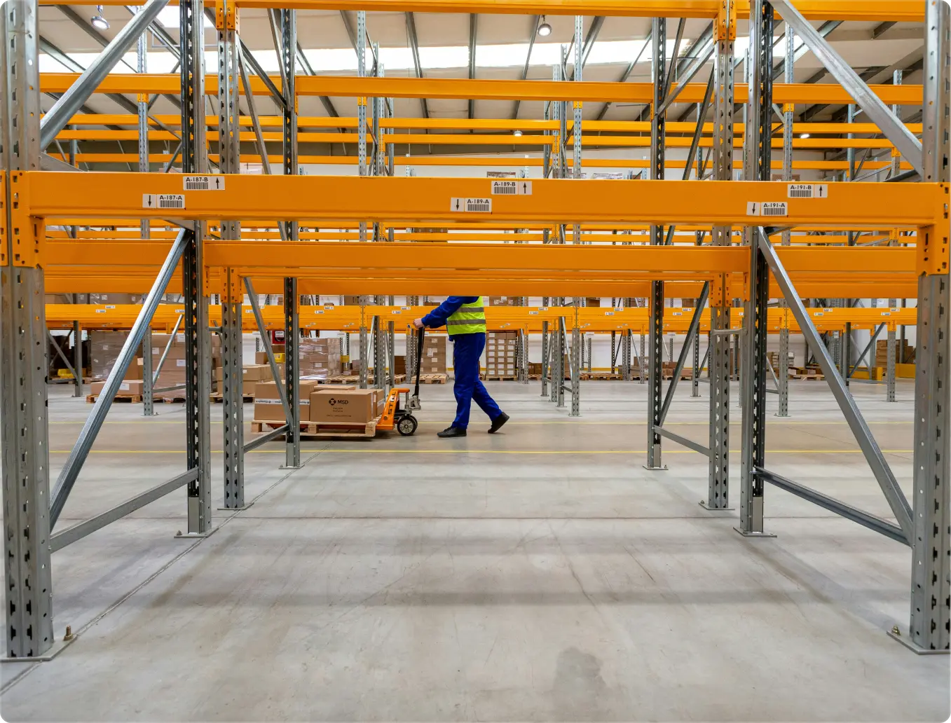 Rear view of a construction worker wearing a white safety helmet and bright yellow reflective vest.