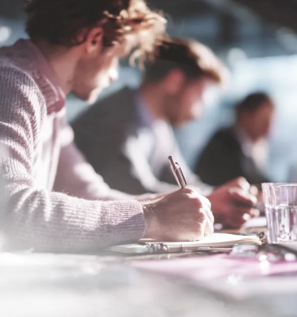 Homem escrevendo num caderno