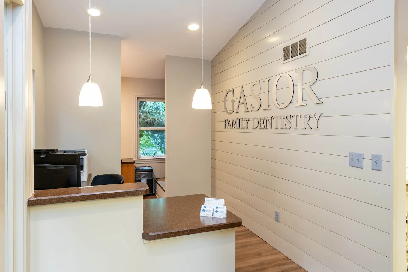 Reception area at Gasior Family Dentistry with front desk and logo wall