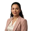 Professional woman with long dark hair wearing a beige blazer and white top, smiling at the camera.