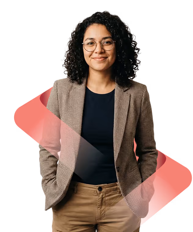 Smiling woman with curly hair, glasses, beige blazer, black shirt, and khaki pants with hands in pockets.