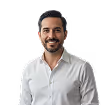 Smiling man with dark hair and beard wearing a white button-up shirt against a white background.