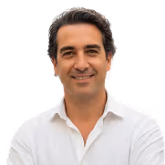 Smiling man with dark hair wearing a white shirt against a white background.