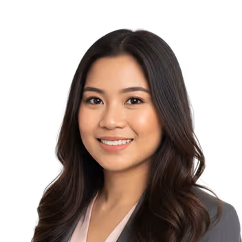 Smiling young woman with long dark hair wearing a gray top.