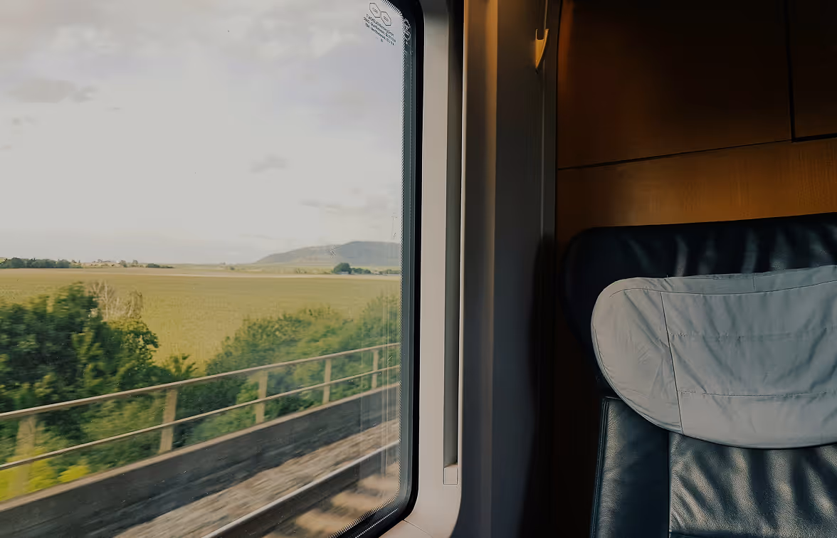 Interior train view: Scenic landscape seen from a comfortable train compartment window.