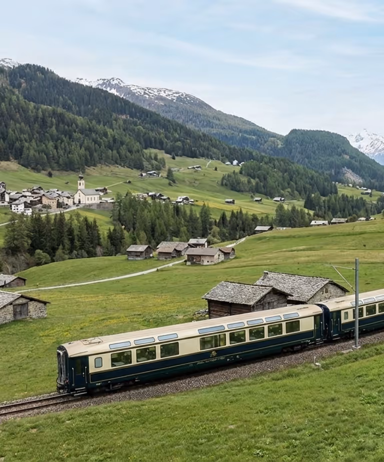 Green valley with a classic train passing through rural landscape.