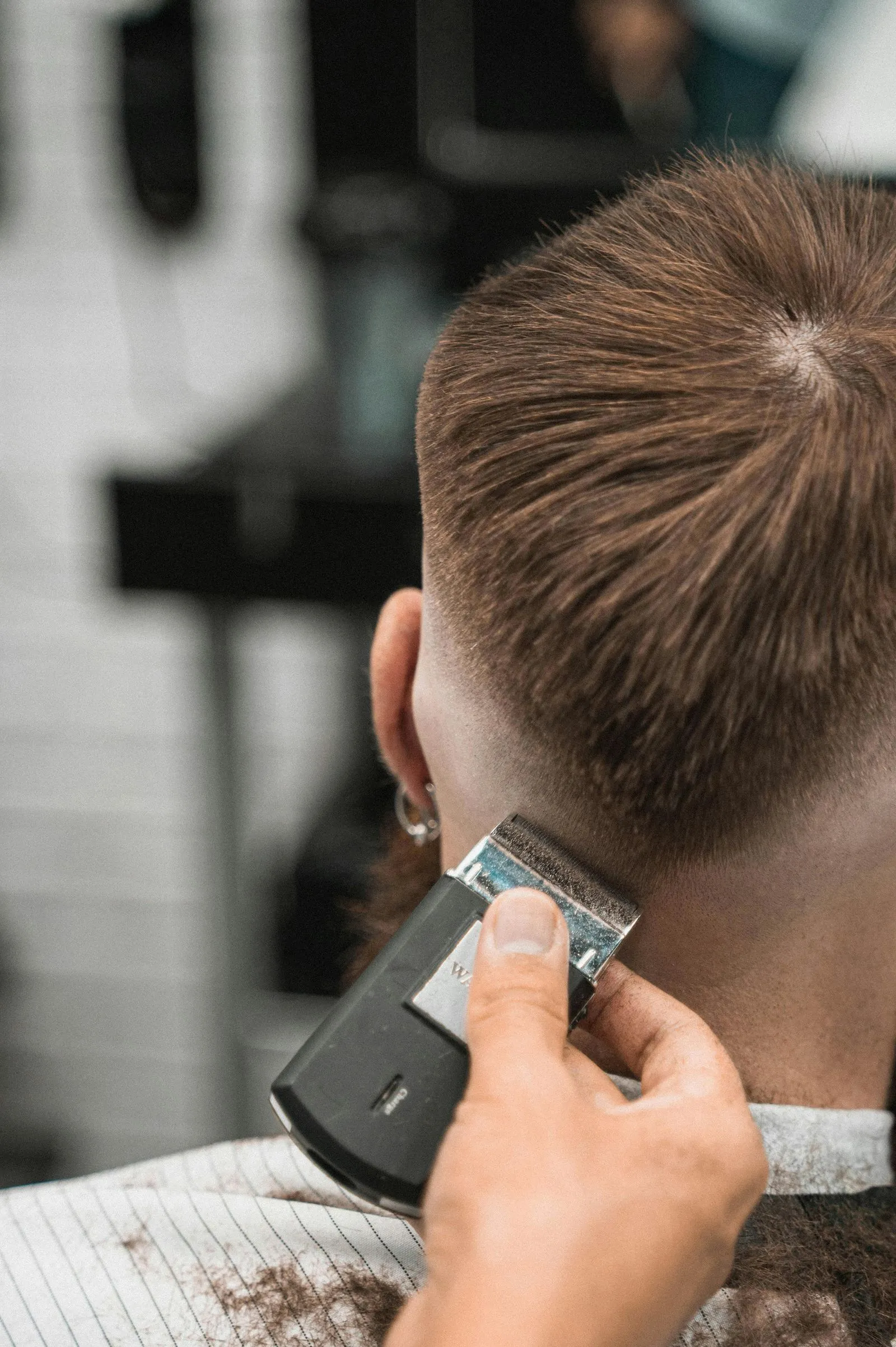 Clipper trimming the back of a man's hair