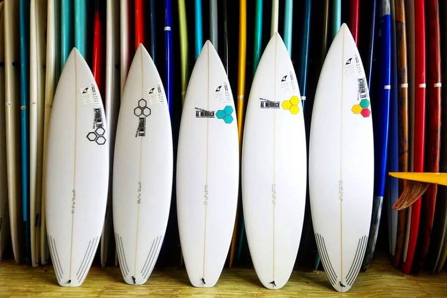 Shortboards standing in front of a surfboard rack