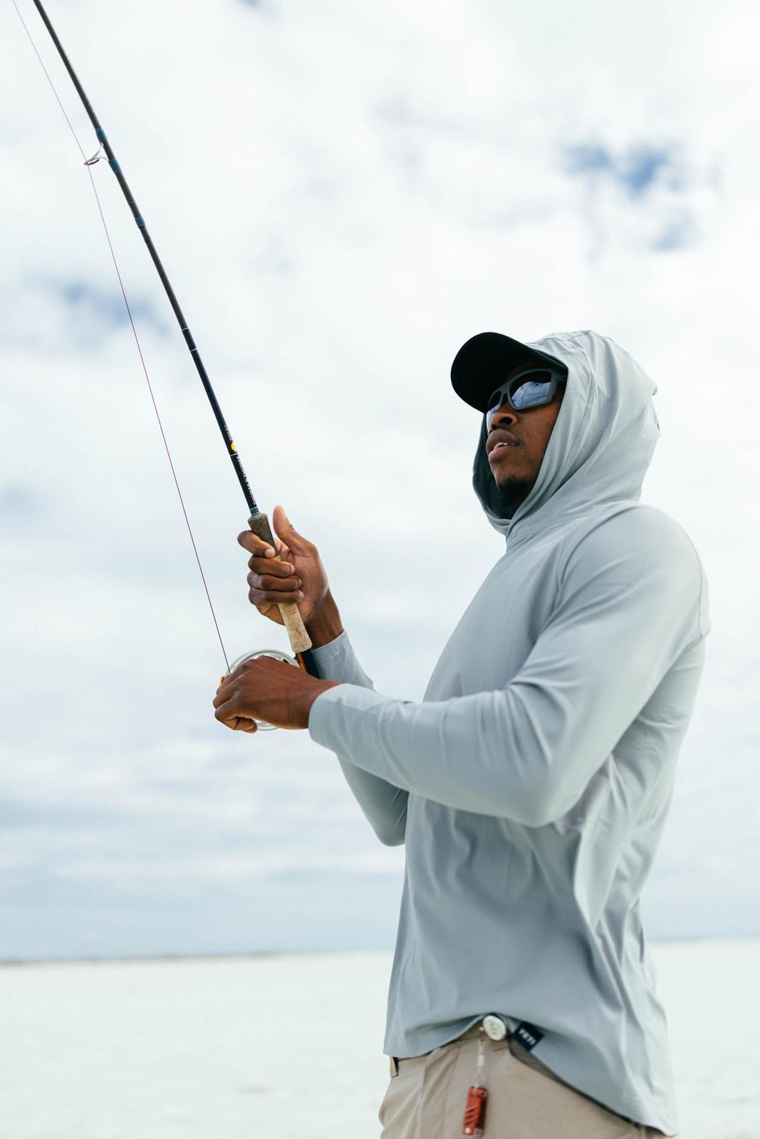LJ Bean fighting a fish on the flats with a fly rod