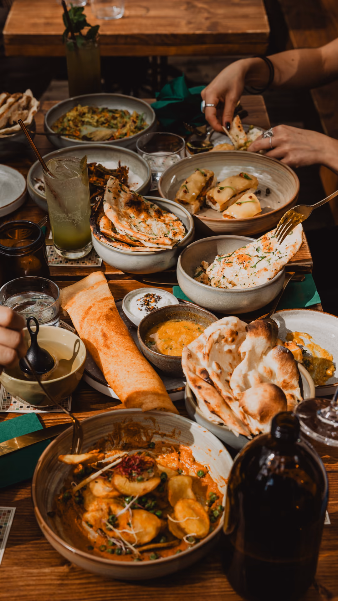 Indian sharing plates and drinks on a table at Miri Mary