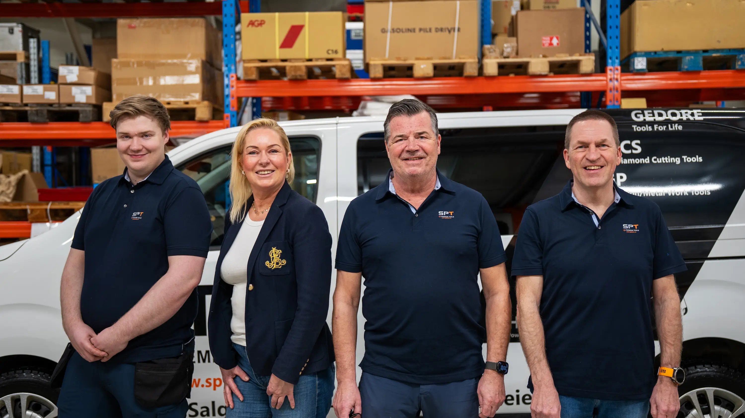 4 ansatte hos SP Tools står sammen foran en bil