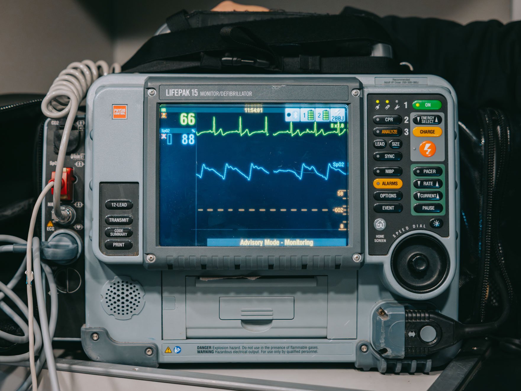 LIFEPAK 15 monitor/defibrillator displaying heart rate, oxygen saturation, and ECG waveforms with control buttons on the side.