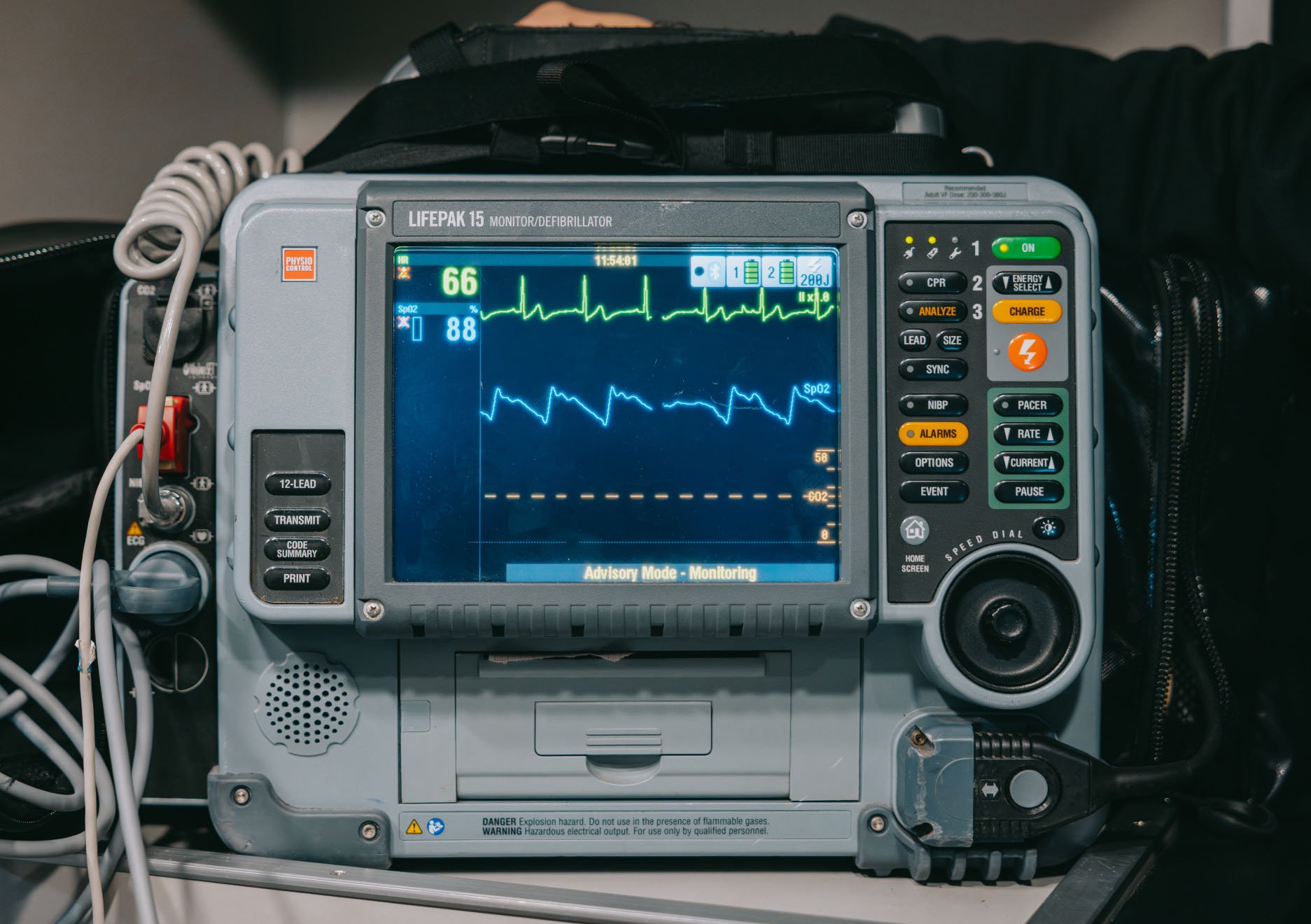 LIFEPAK 15 monitor/defibrillator displaying heart rate and oxygen saturation waveforms with control buttons and dials.