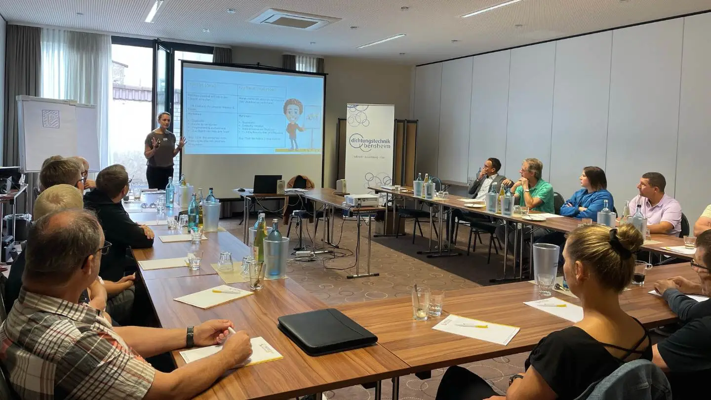 Das Team der Dichtungstechik GmbH sitzt im OKR-Workshop und hört tgim zu.