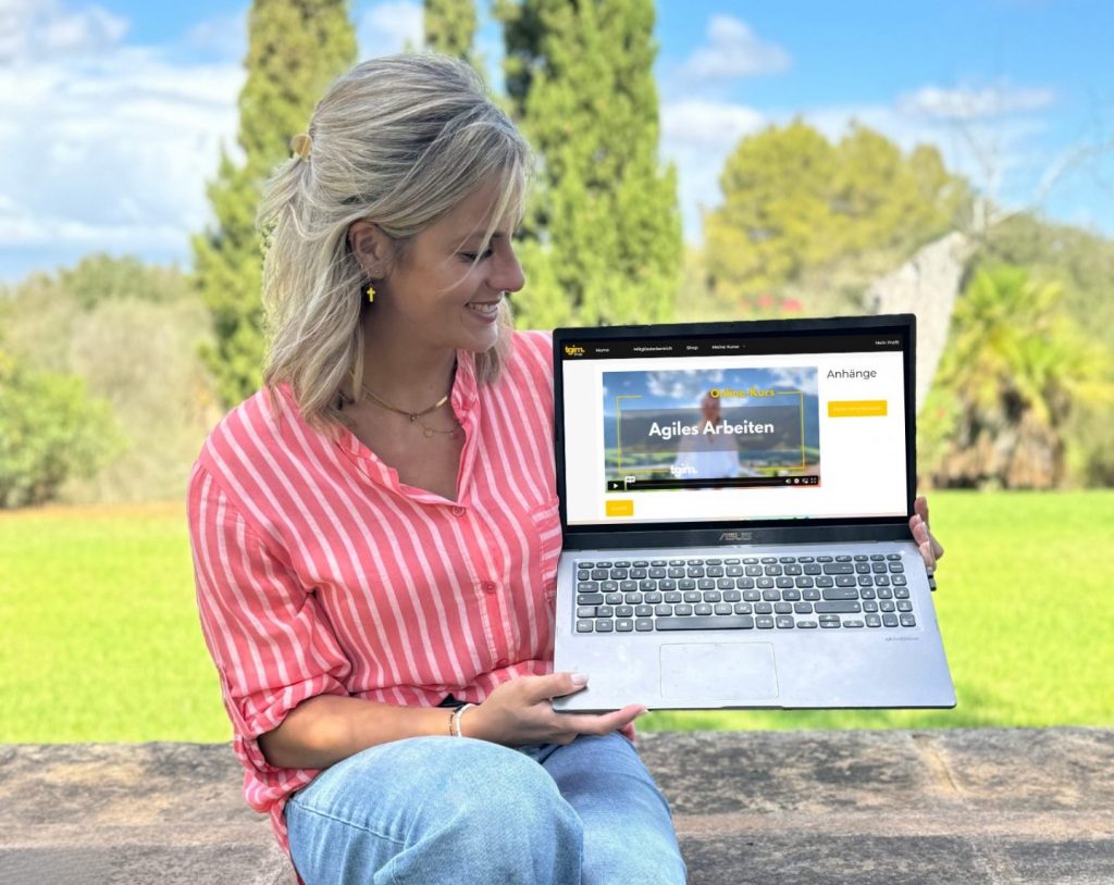 Sabine von tgim schaut auf einen Laptop, auf dem ein Ausschnitt des Online-Kurses zu sehen ist.