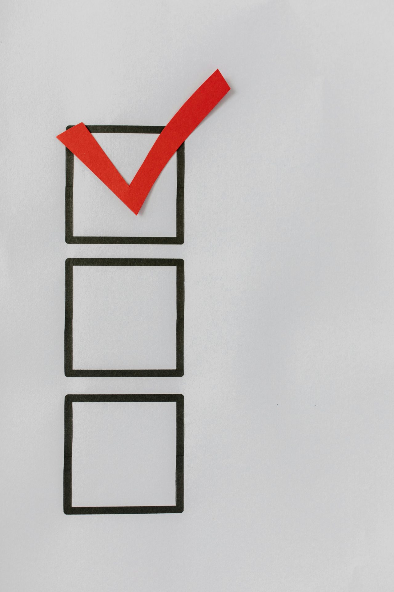 Checkliste mit drei Kästchen, von denen das erste mit einem roten Haken markiert ist.