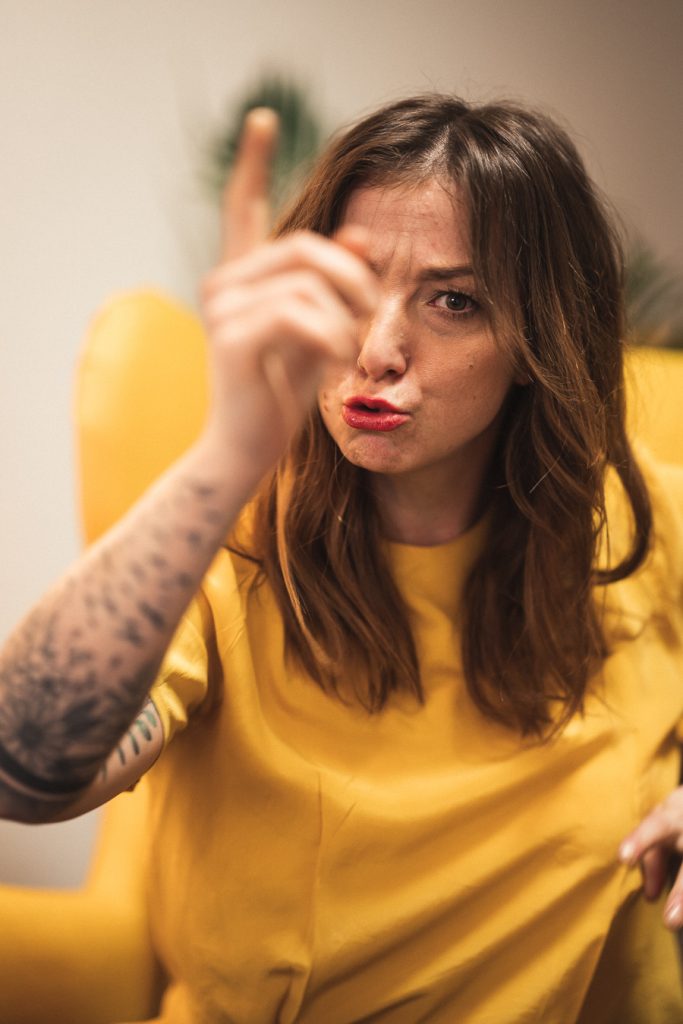 Tanja von tgim zeigt mit ernstem Gesichtsausdruck warnend den Zeigefinger nach oben.