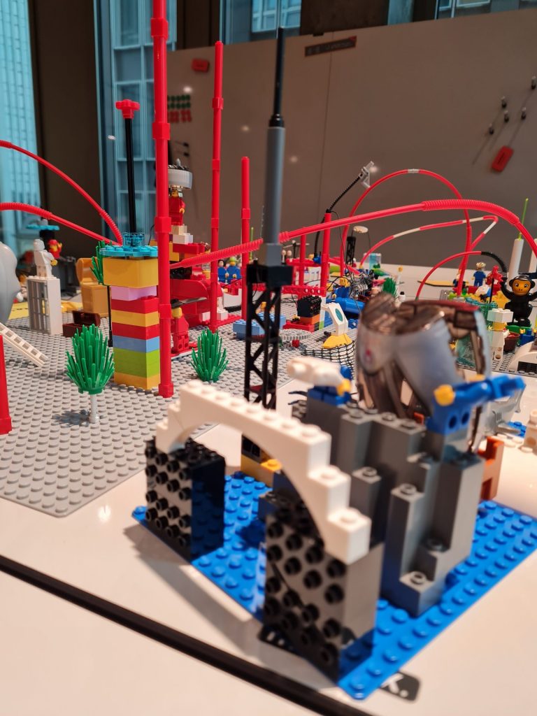 Komplexes LEGO Serious Play Modell mit Brücken, Figuren und Verbindungselementen zur Darstellung von Organisationsstrukturen und Zusammenarbeit.