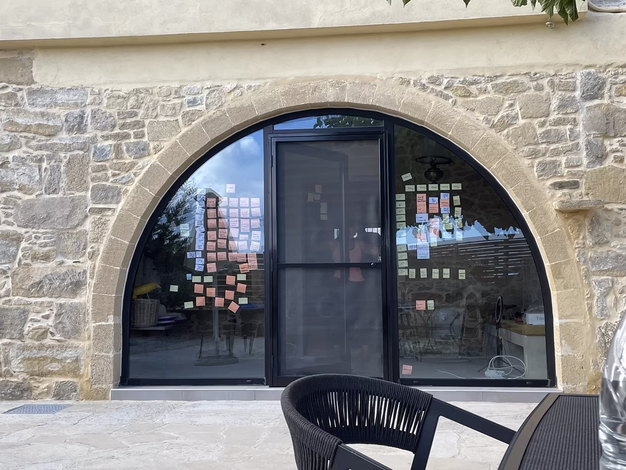 Workshop-Ergebnisse mit Haftnotizen an einem großen Fenster in einem historischen Steingebäude.