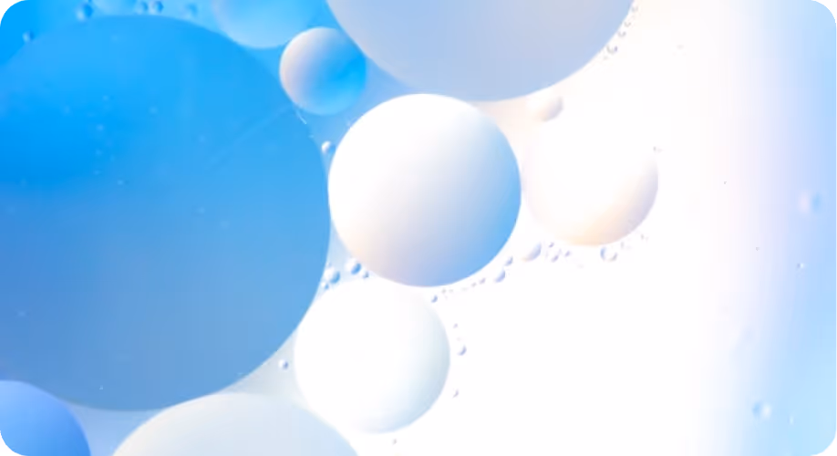 Esferas blancas y azules flotando sobre un fondo claro y difuso.