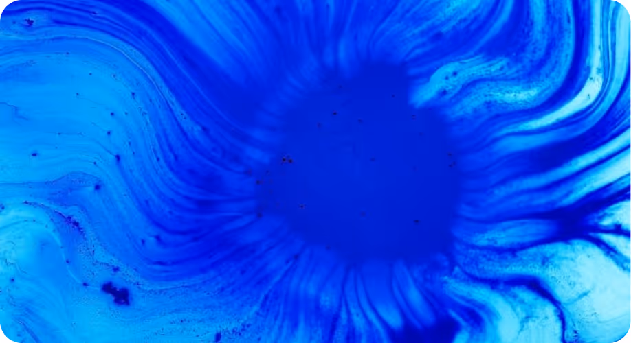 Manchas y patrones abstractos en tonos azules oscuros y claros que se expanden desde un centro oscuro.