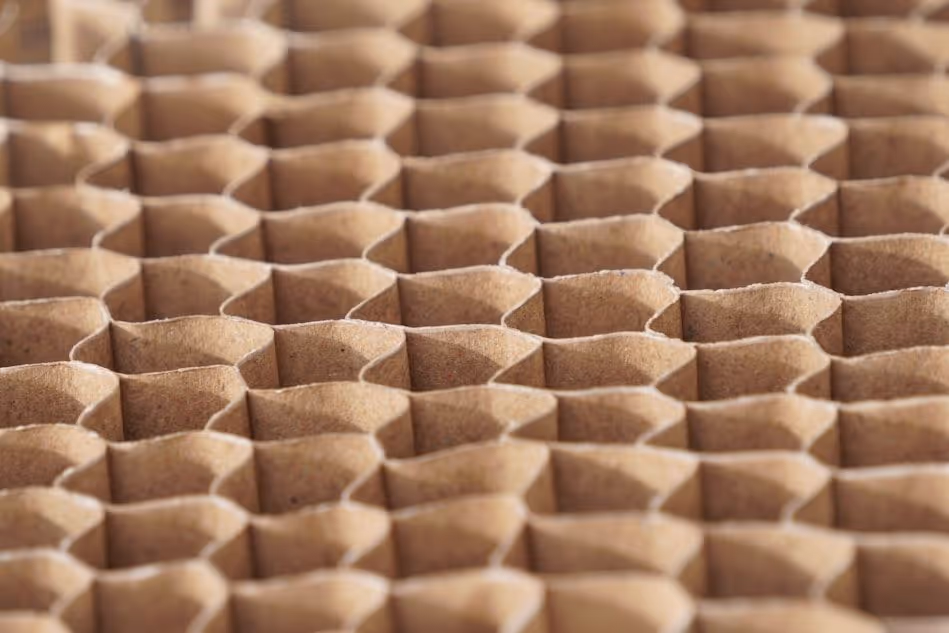 Primer plano de una estructura de panal de abeja de cartón marrón con celdas hexagonales.