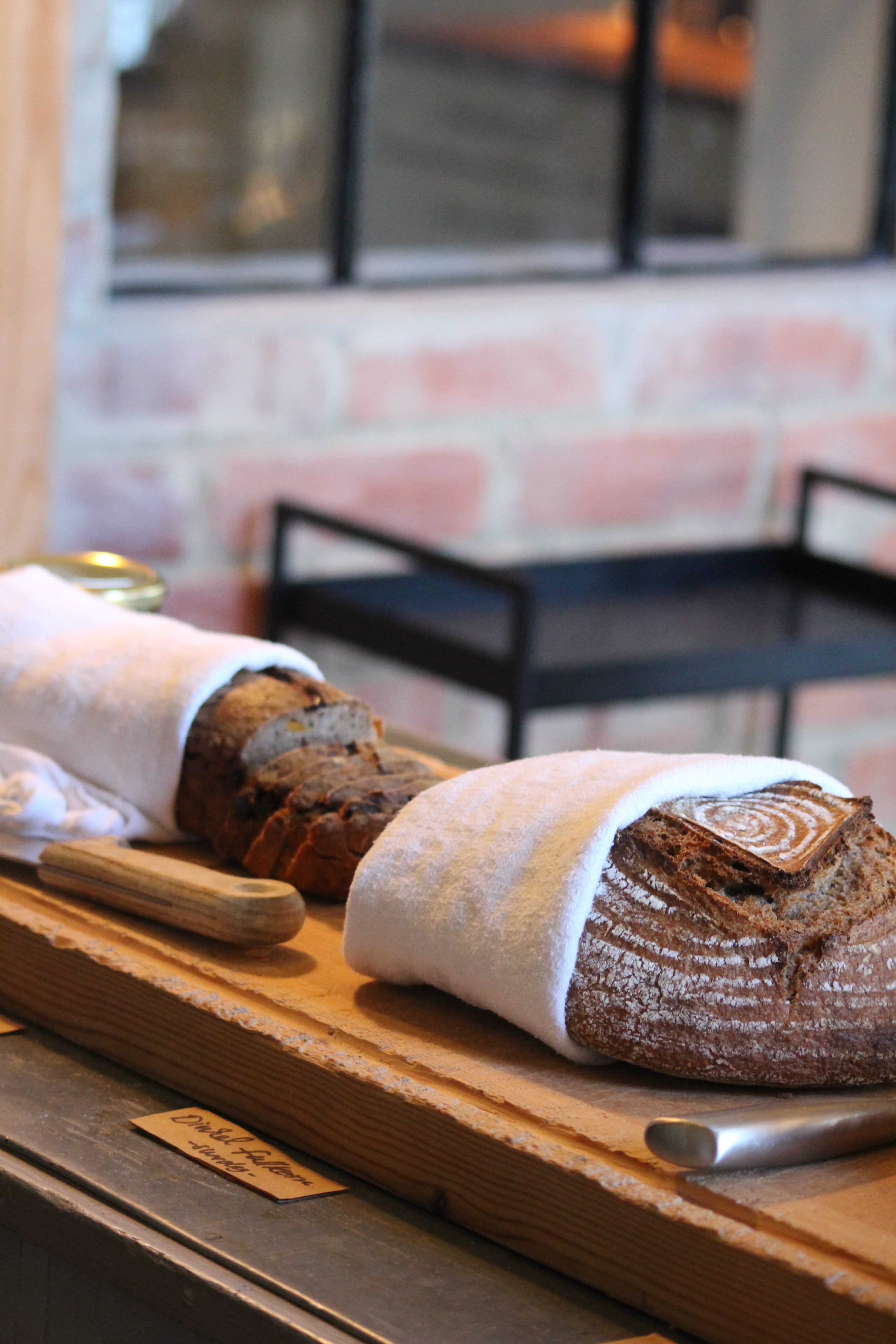 Grilled prawns artfully arranged on a black stone plate, garnished with herbs, showcasing vibrant colors and textures.