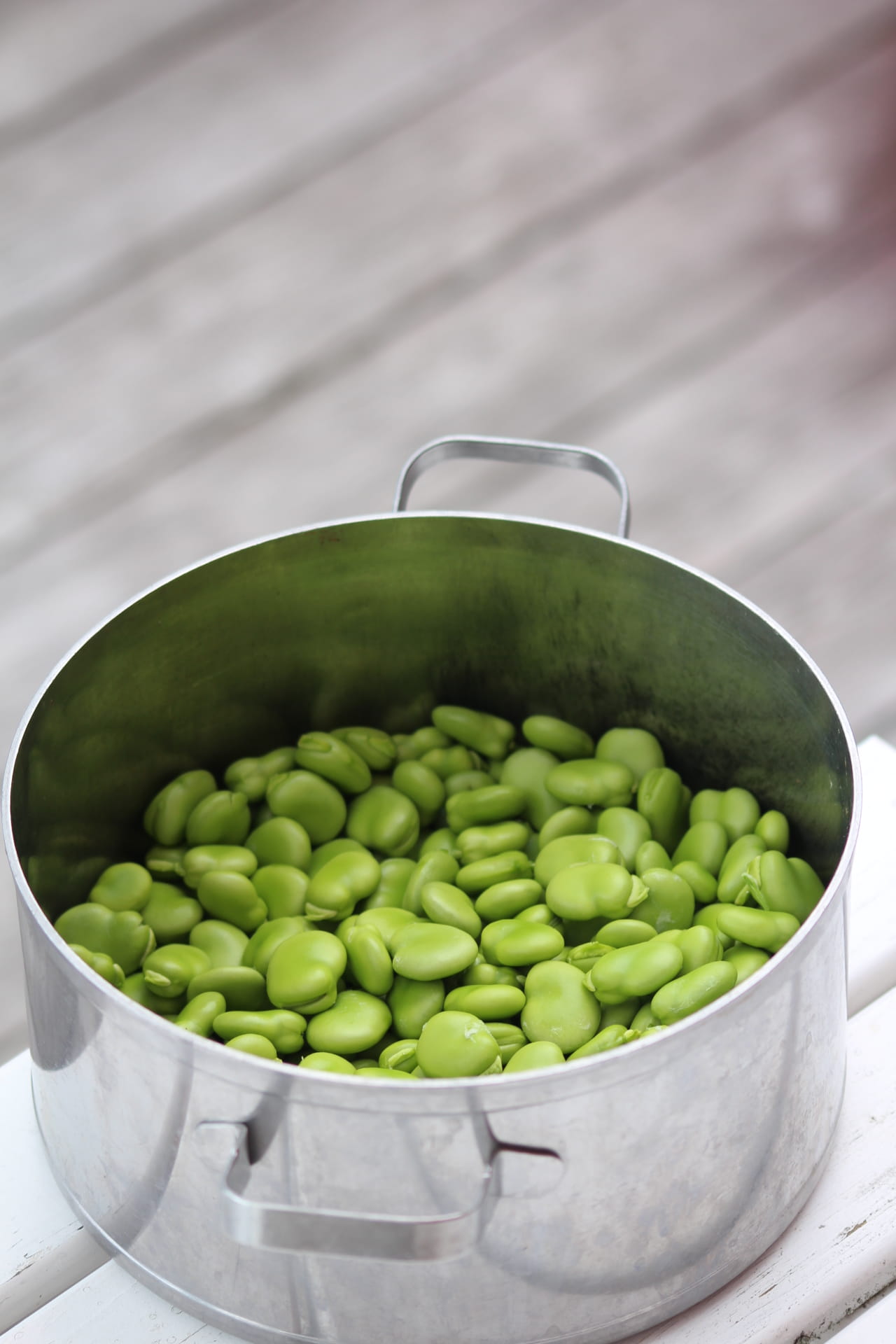 Delicious dessert served in a bowl, featuring creamy layers topped with nuts, chocolate drizzle, and colorful sprinkles. Spoon resting beside.