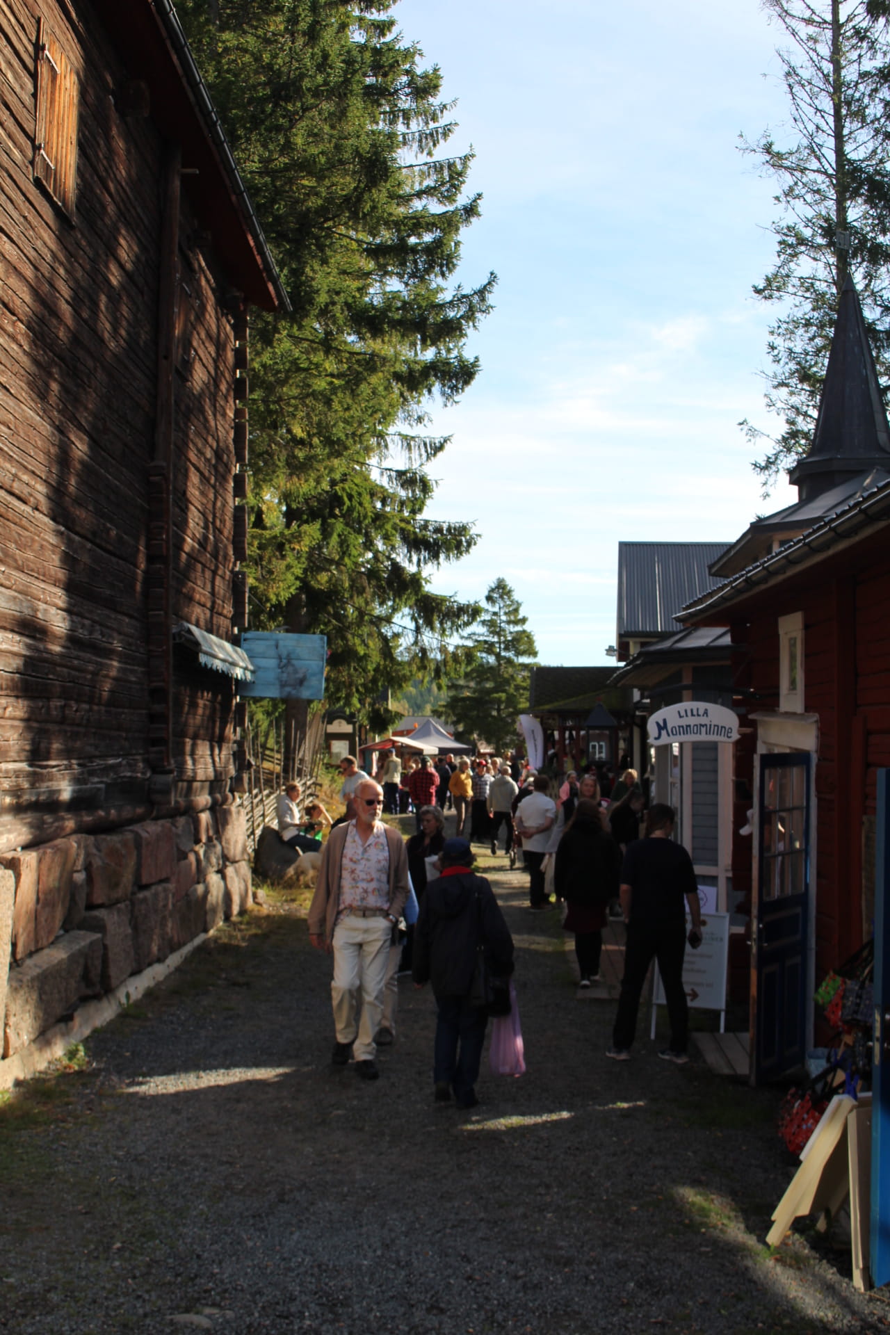 A serene coastal view featuring a rocky outcrop, gentle waves, and a vibrant sunset sky, framed by lush greenery.