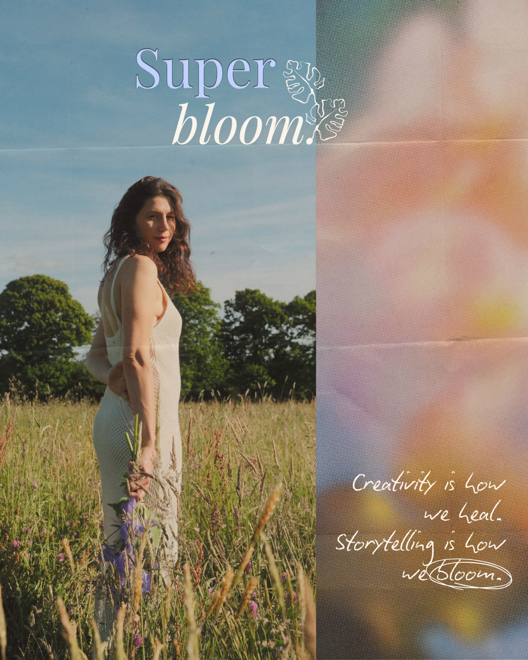 Woman in white dress holding flowers stands in a sunlit field with trees and blue sky.