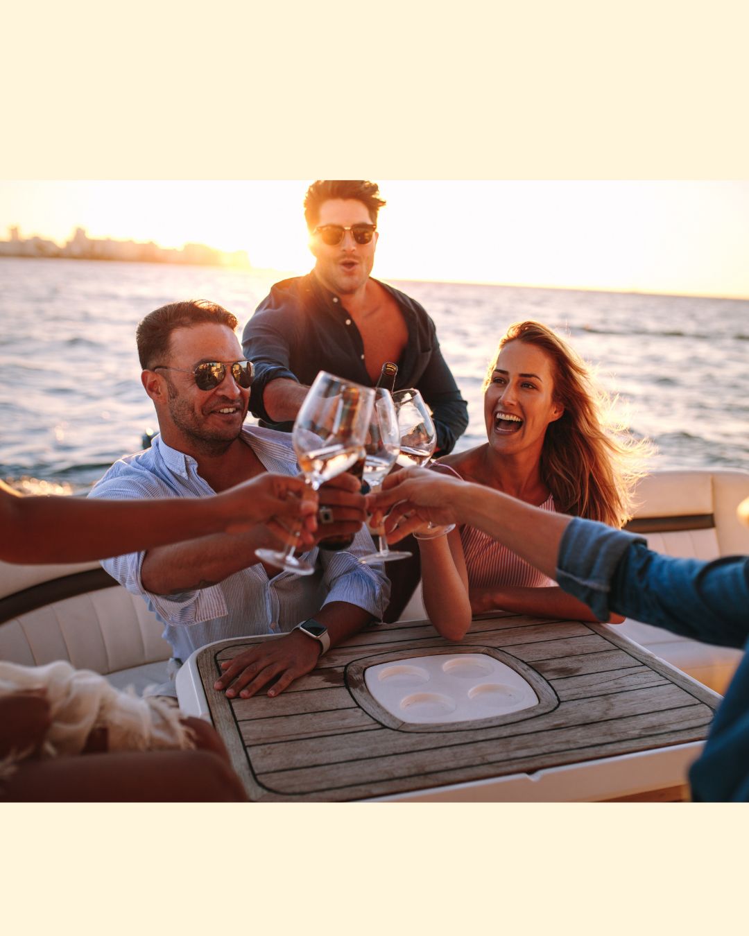 View of two large yachts docked on either side of a peaceful blue marina with buildings and greenery in the background under a clear sky.