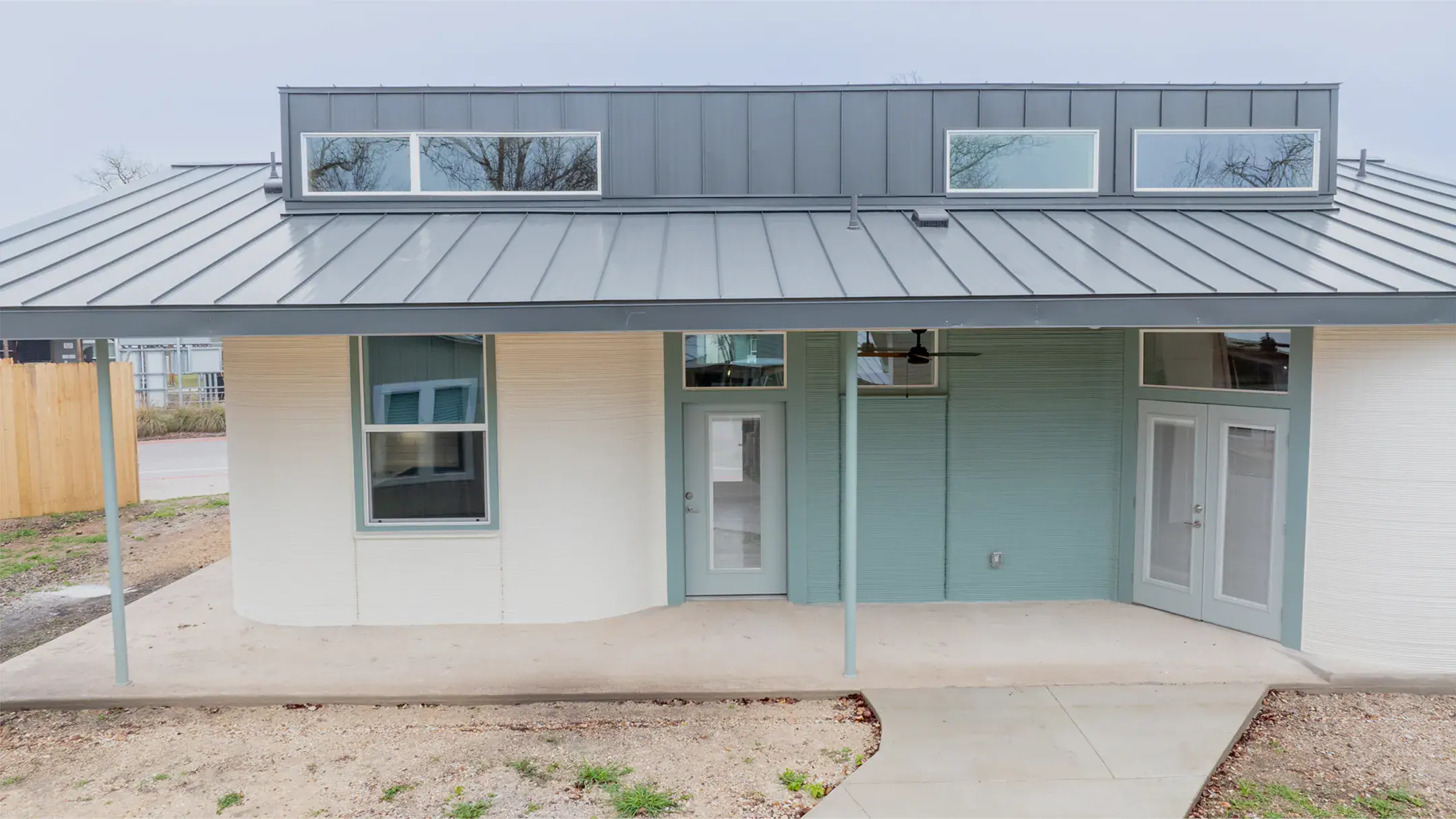 Front porch of a modern home with metal roof, central glass door and right-side French doors