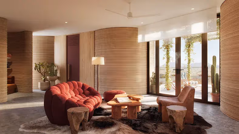 Living room with red tufted sofa, wooden stools, fur rug, and glass doors opening to a patio