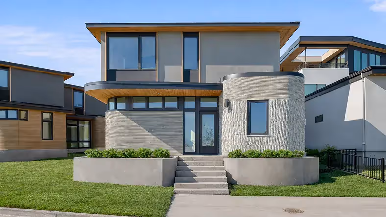 Contemporary two-story home with curved concrete façade, central steps, and large windows