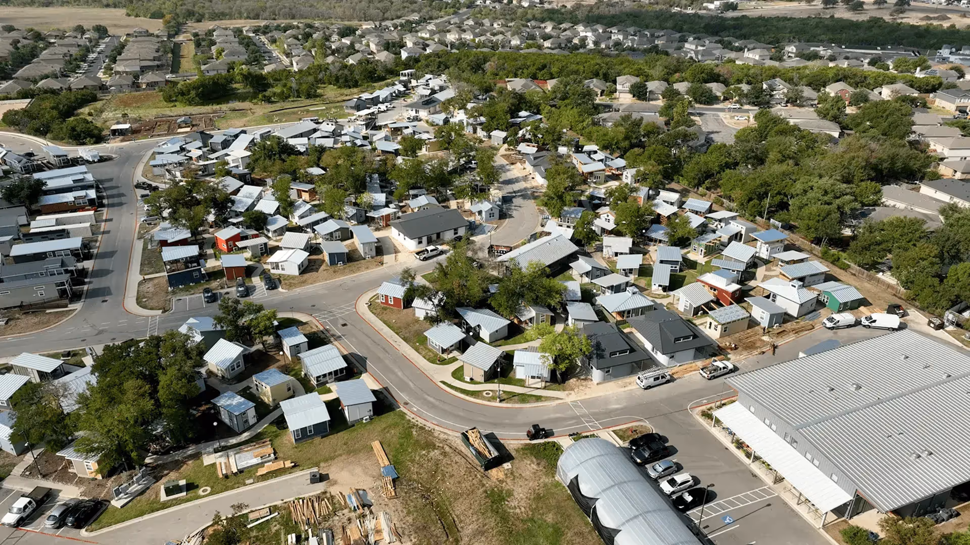 Aerial view of a dense neighborhood of small modern houses with metal roofs