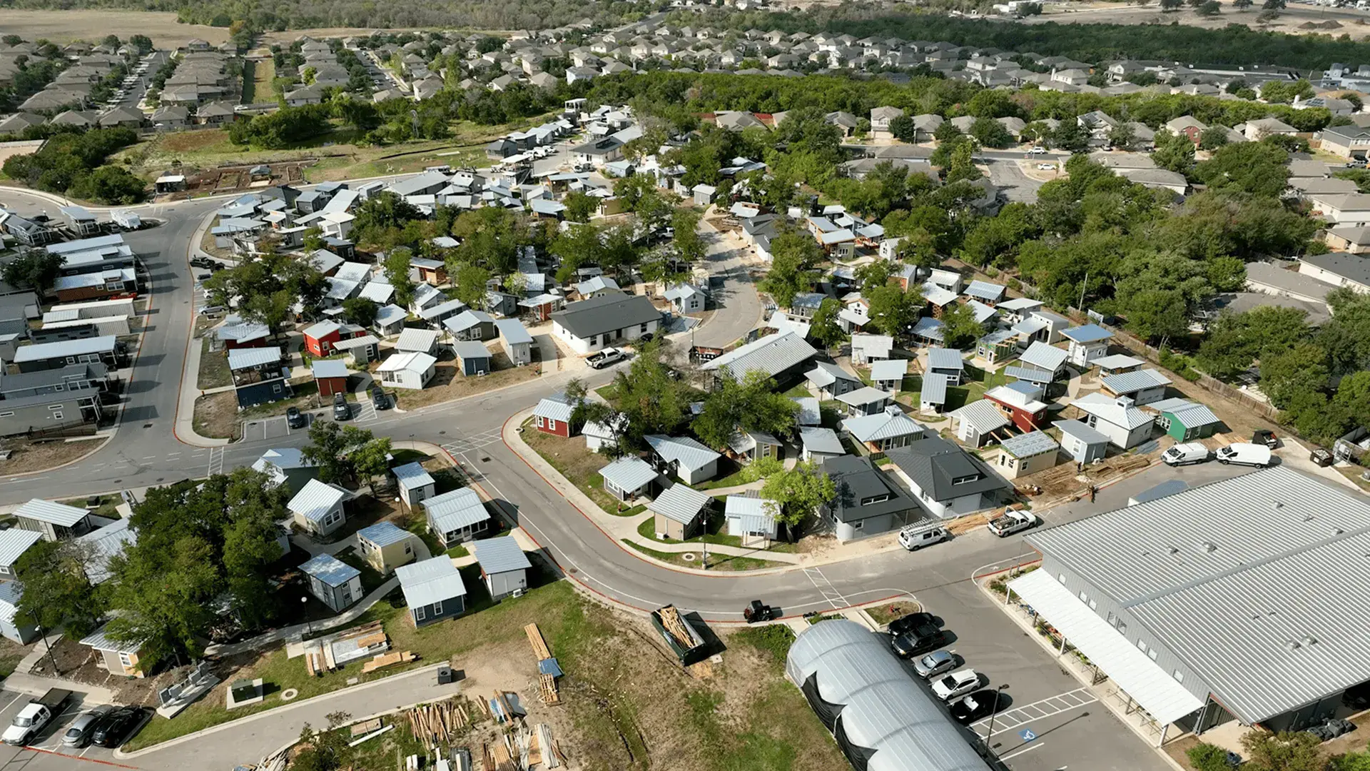 Aerial view of a dense neighborhood of small modern houses with metal roofs