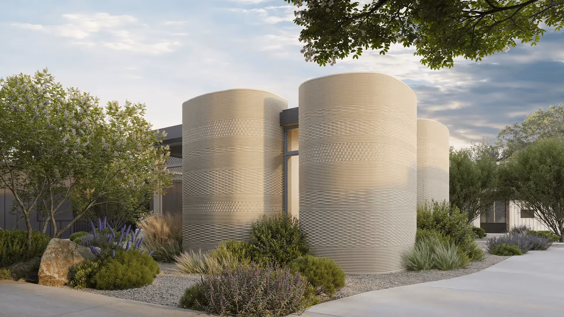 Textured cylindrical 3D-printed exterior walls of a modern home with landscaping